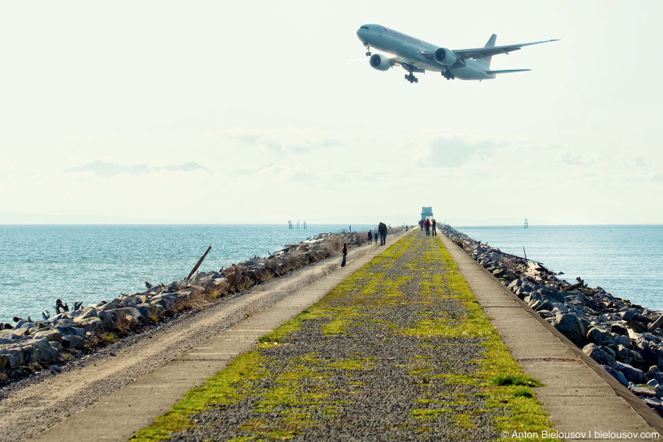 Самолет заходит на посадку в междуародный аэропорт Ванкувера YVR над косой Iona Jetty