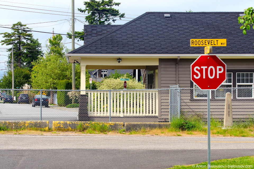 Вид на Канаду и ее зеленые уличные указатели с Американской стороны (Point Roberts, WA)