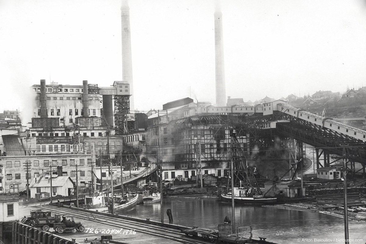 View of the Powell River Company Mill, 1926. Model T Ford wagons are parked on the wharf.